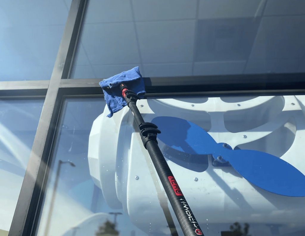 Image of a window washing tool against a storefront window