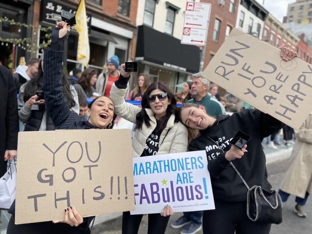 Marathon supporters with signs on Mile 8